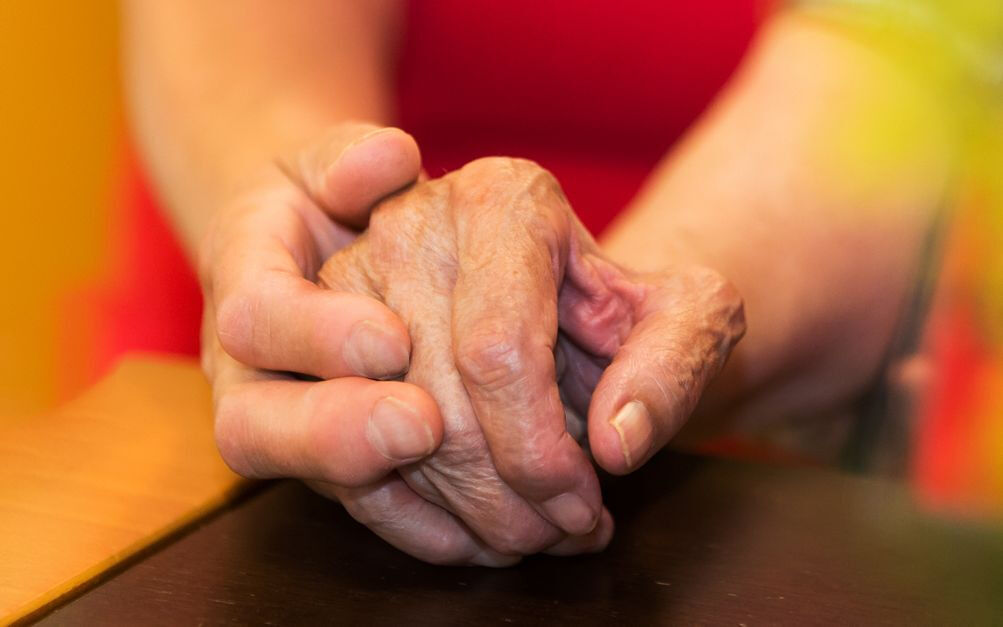 Eine junge und eine ältere Hand halten einander, Trost, Nachbarschaftshilfe Rosenheim