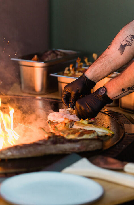 Nahaufnahme Eventgrillen am offenen Feuer, Impression Eventfotografie